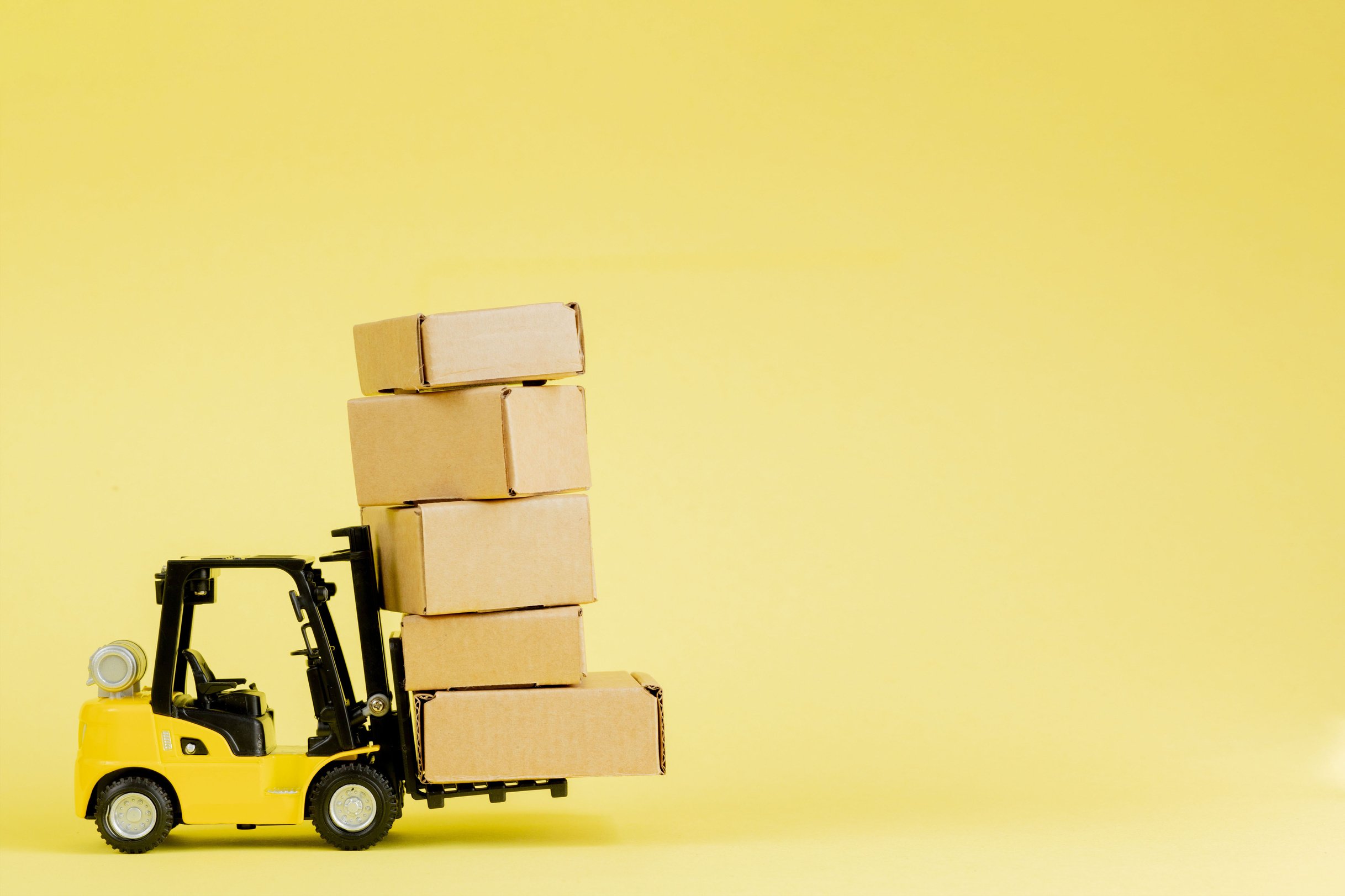 Mini forklift truck load cardboard boxes. Logistics and tran