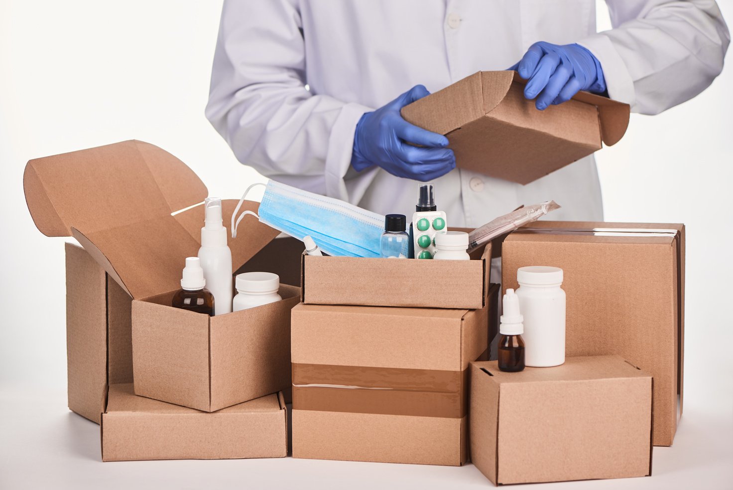 Pharmacist packing ordered medications and supplies into cardboard boxes